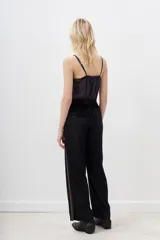 Pantalón palazzo negro de terciopelo con cintura elástica y detalle de bordado dorado en los laterales.