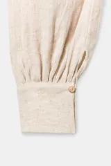 Pantalón bombacho de tiro medio, color beige claro, confeccionado en mezcla de lino. Presenta bolsillos laterales y bajo abullonado terminado en puño con botón.