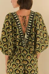 Mono largo con estampado geométrico en tonos negro, verde y dorado. Escote en V pronunciado con bordados en los bordes y mangas amplias.