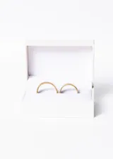 Set de dos alianzas anchas de acero quirúrgico color dorado, con terminación pulida.