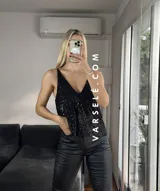 Musculosa plateada con lentejuelas, escote en V y tirantes finos.