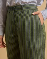 Pantalón de lino verde con rayas verticales negras y blancas, de tiro alto, corte palazzo y bolsillos laterales.