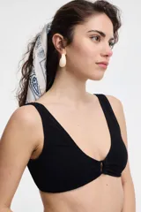 Top de bikini negro texturado con escote en V y detalle de aro metálico en el centro.