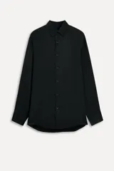 Camisa negra fluida confeccionada en hilatura con cupro, de cuello solapa y manga larga acabada en puño. Cierre frontal con botones.