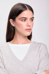 Sweater gris claro de tejido de punto con escote en V y corte holgado.