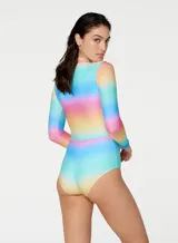 Traje de baño enterizo de lycra con mangas largas y cierre frontal, estampado con degradé de colores: celeste, amarillo, naranja, rosa y violeta.