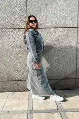 Falda larga gris de denim, con corte recto, abertura lateral y bolsillo cargo con solapa en la pierna.
