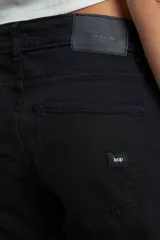 Pantalón de jean negro, de corte ajustado en cintura y caderas, con pierna ancha.