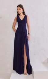 Vestido largo de fiesta color azul marino, con escote en V, sin mangas, corte imperio, falda con abertura lateral y detalle de volados en diagonal.