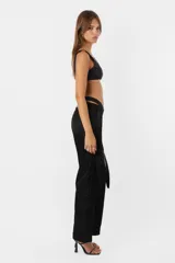 Pantalón negro de tiro medio y corte recto con cartera en diagonal y cintura larga.