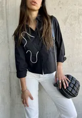 Camisa negra de corte cropped con diseño original en relieve, ideal para un look moderno.