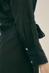Vestido camisero largo negro de algodón con lazo en la cintura, botones nacarados y detalle de Polonio en cobre. Hecho en Italia.