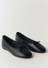 Ballerinas negras de cuero con punta redonda y lazo decorativo.