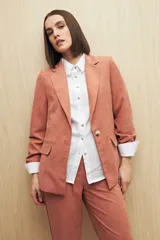 Blazer color beige de corte clásico en tela jaspeada, suave al tacto, liviana y con caída relajada.
