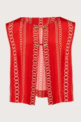 Chaleco rojo con estampado de cadenas doradas, sin mangas y con cuello redondo. Cierre frontal con ojales, botones dorados y cordones entrelazados.