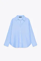 Camisa celeste de corte clásico, cuello solapa, escote en pico y manga larga.