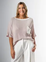 Remera tejida en hilo italiano, color beige, con cuello a la base y bolsillo frontal. De caída relajada y silueta amplia.