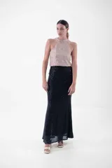 Vestido largo de fiesta con cuello halter y lentejuelas color verde esmeralda en el top y negro en la falda.