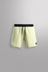 Shorts deportivos color verde claro con cintura elástica negra ajustable con cordón, bolsillos laterales, bolsillo de seguridad trasero con cierre, aberturas laterales y logo estampado en la pierna.