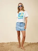 Remera corta rosa de algodón con estampa rectangular en el frente que incluye una palmera, el sol y el texto "Paradise Club".