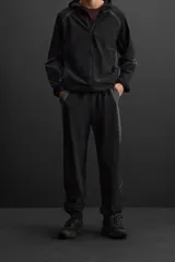 Pantalón relaxed fit confeccionado en tejido técnico ligero y elástico en todas direcciones. Cintura elástica ajustable con cordón interior, bolsillos delanteros y bajo acabado en elástico y ajustable con cremallera.