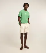 Remera verde con estampa de la marca Kodak y photoprint de playa paradisíaca.