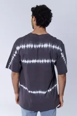 Remera gris oscuro con diseño tie dye de rayas horizontales blancas.