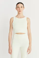 Top deportivo color crema, de cintura ancha y compresión suave, con recortes en el delantero.