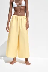 Pantalón culotte amarillo de tiro medio con cintura elástica y bolsillos laterales ocultos en la costura.