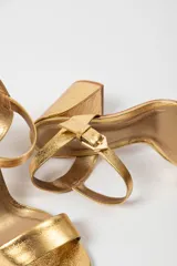 Sandalias de tacón alto color lila, con tira delantera y tobillera con hebilla dorada.