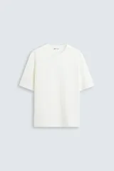 Camiseta color blanco con textura, de corte holgado, cuello redondo y manga corta.