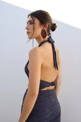 Top corto azul con brillos, escote halter y espalda descubierta.