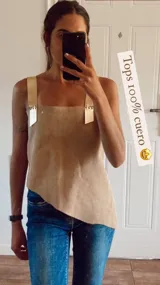 Top color beige de cuero con corte asimétrico y tirantes gruesos.