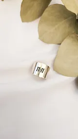 Anillo ancho de plata 925 con la inscripción "11:11" calada en el frente.