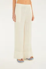 Pantalón de algodón color crudo, de corte amplio y fluido, con cintura ajustable con cordón. Presenta textura acanalada vertical y bolsillos laterales.