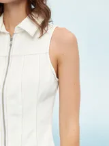Chaleco blanco con cierre frontal de cremallera y cuello camisero.