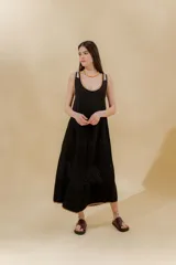 Vestido midi negro de punto con diseño de bloques en diferentes texturas, escote redondo y sisas con terminación ondulada.