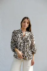 Camisa de manga larga con cuello mao y estampado animal print en tonos crudo, negro y marrón.
