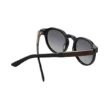 Lentes de sol Indie Honey con montura redonda negra y lentes grises degradé.