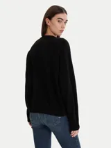 Sweater negro de calce relajado con cuello redondo y mangas largas, con terminaciones acanaladas en puños y ruedo.