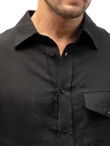 Camisa negra de lino con mangas 3/4, un bolsillo en el lado izquierdo y un pliegue en la espalda. Cierre con botones. Marca KAI.