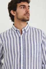 Camisa de lino a rayas verticales azules y blancas, de manga larga con puños abotonados y cuello clásico.