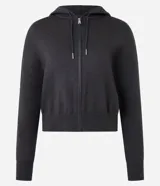 Campera corta de mujer con capucha ajustable con cordón, cierre frontal de cremallera y puños y bajo ajustados. Confeccionada en tejido de punto.