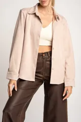 Camisa color marrón de gamuza sintética, de corte recto, con cuello clásico, cierre frontal con botones y mangas largas.