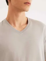 Conjunto de pijama para hombre compuesto por una remera azul marino de manga corta con cuello en V y un short a cuadros en tonos azul, gris y blanco.