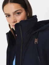 Campera Tommy Hilfiger azul marino, acolchada, con cierre de cremallera, cuello alto, capucha con cordones ajustables y bolsillos laterales.