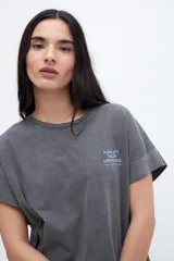 Musculosa celeste con estampado pequeño en el pecho, corte oversize y mangas con dobladillo.