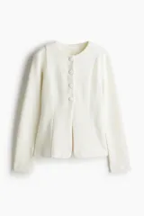 Saco blanco de punto bouclé con cuello redondo, botones forrados hasta la cintura y corte acampanado en la parte inferior.