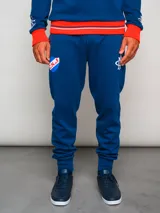 Pantalón de jogging azul con puños ajustados, cintura elástica con cordón y escudo del Club Nacional de Football en la pierna izquierda.