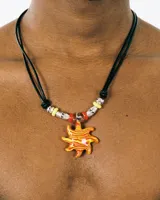 Collar con cordón negro y dije de sol naranja con vetas amarillas. Incluye cuentas plateadas, amarillas y rojas.